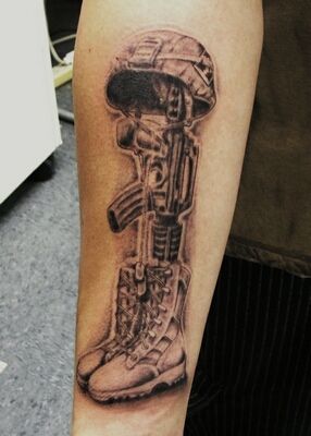 a tattoo on the arm of a man with an army boot