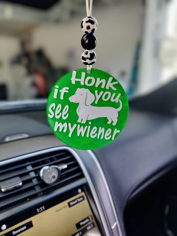 a keychain that says honk if you see my wiener hanging from the dashboard of a car