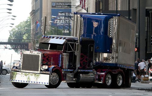 a large semi truck driving down a city street