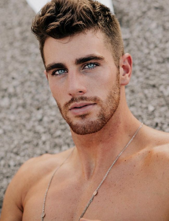 a shirtless man with blue eyes is posing for the camera