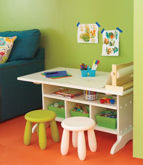 a child's playroom with green walls and white furniture, including stools