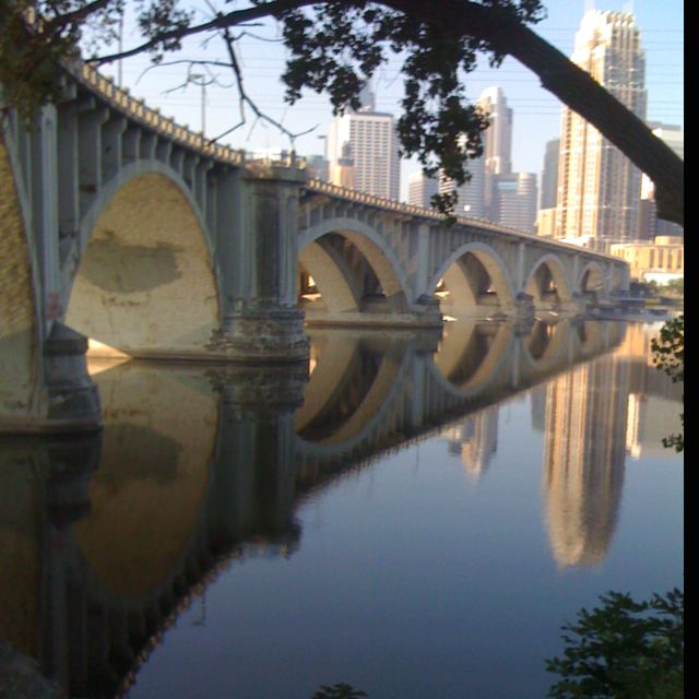 an old bridge is reflected in the water