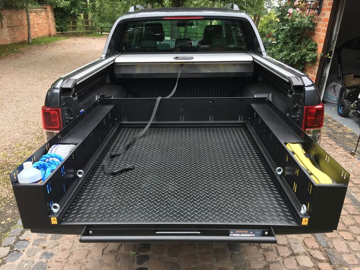 the back end of a pickup truck with its cargo compartment open and water bottles in it