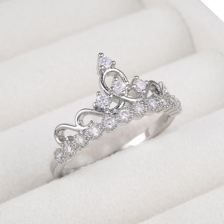 a white gold ring with diamonds on it in a gift box for someone's special occasion