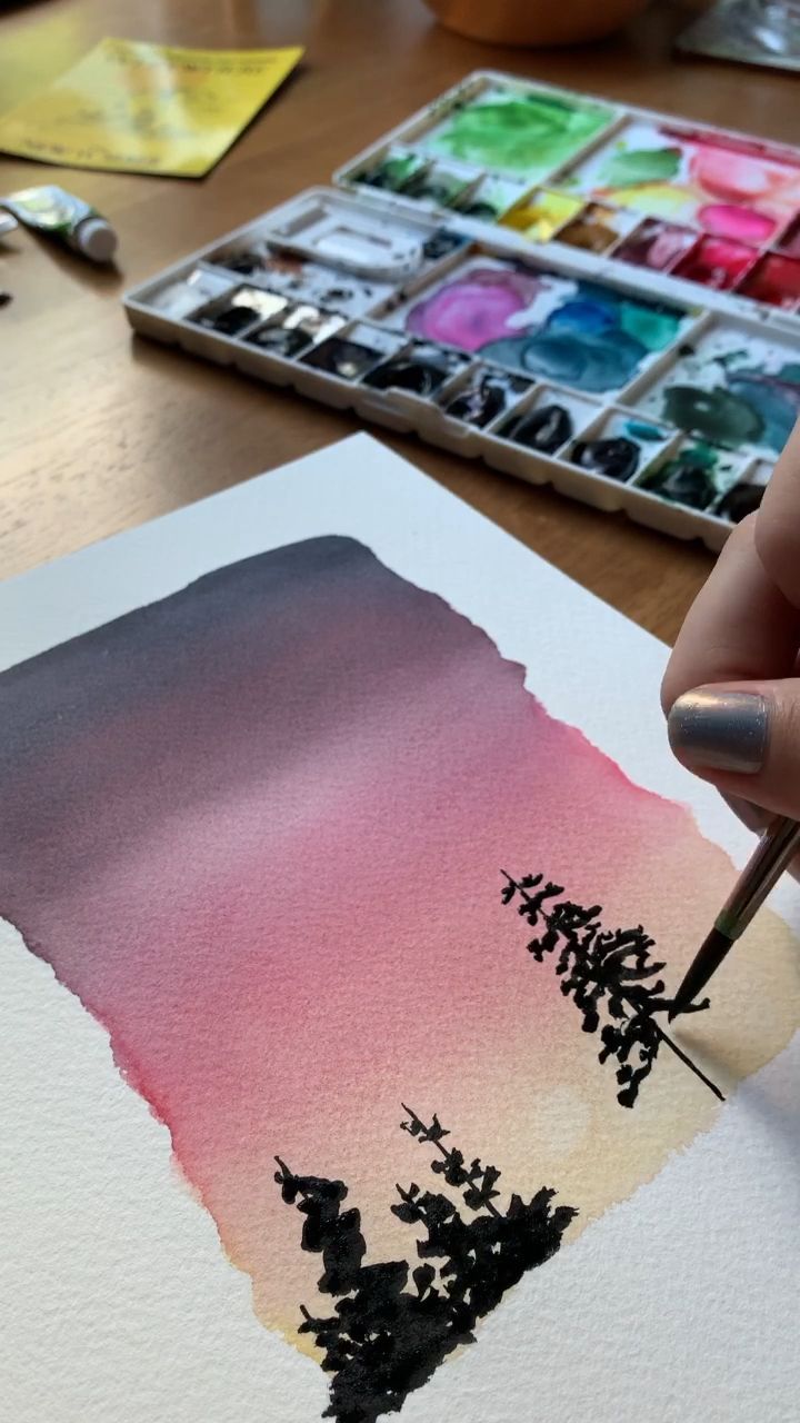 a person is painting with watercolors on paper and using a brush to ...