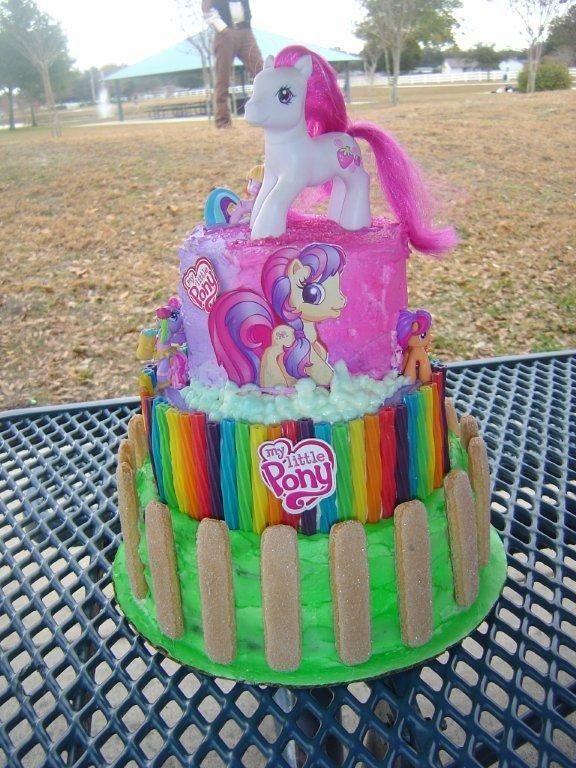 there is a cake that looks like a pony on top of the cake and has rainbow icing