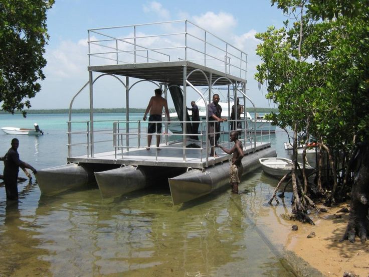 some people are standing on a boat in the water and one is getting ready to go