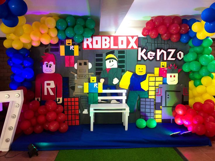 a room filled with balloons and decorations on the walls, including a robot themed wall