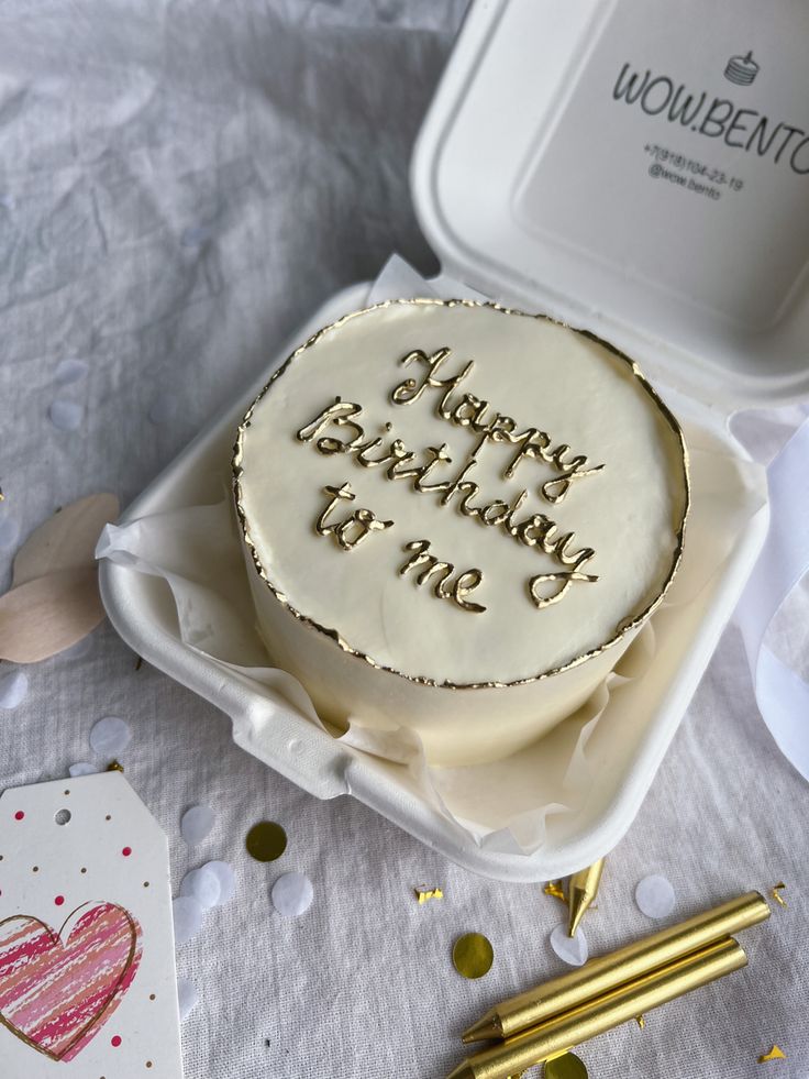 a birthday cake with writing on it sitting in a box