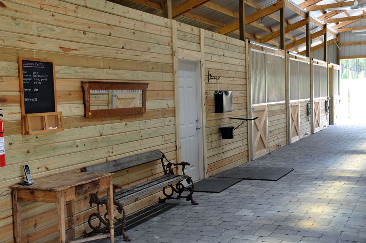 the inside of a building with wooden walls and benches on either side of the door