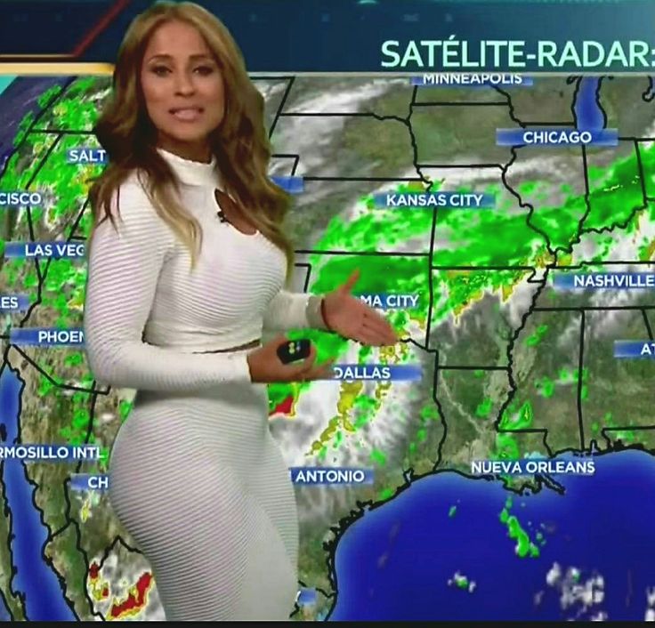 a woman in a white dress is standing next to a weather map and holding her hand out