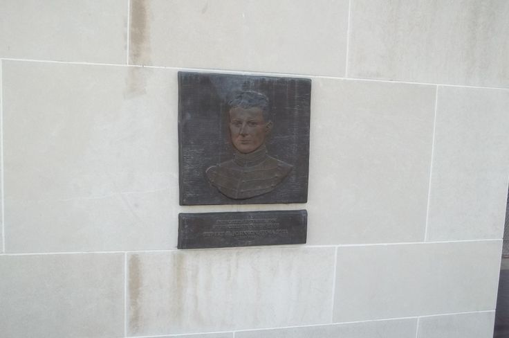 a plaque on the side of a building with a portrait of a man in it