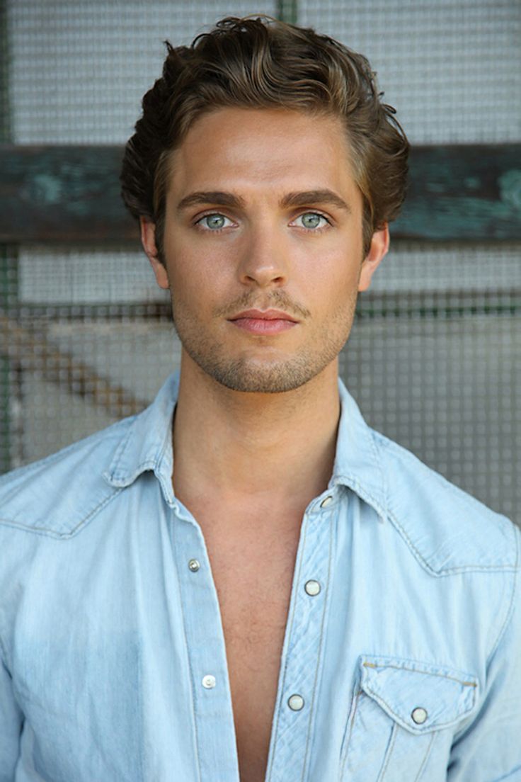 a man in a blue shirt posing for the camera