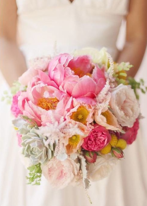 a bridal holding a bouquet of pink and white flowers on her wedding day,