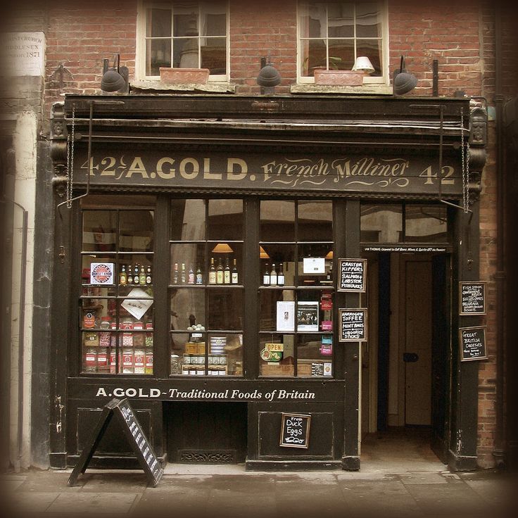 an old fashioned store front with signs on it