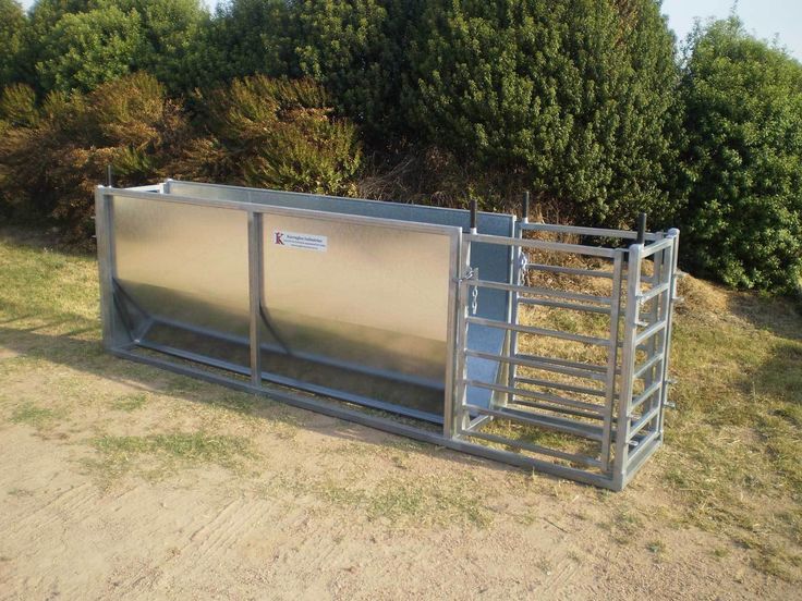 a cattle trailer is parked in the grass