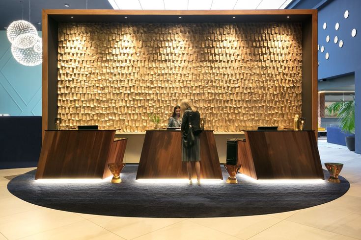 two people are standing in front of a wall made out of gold coins and vases