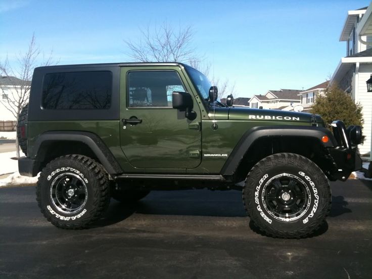 a green jeep parked in a parking lot