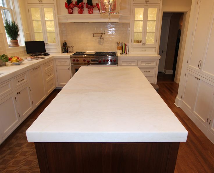 a kitchen with white cabinets and an island