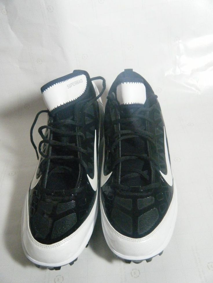 a pair of black and white nike shoes on a white sheeted surface with the soles off