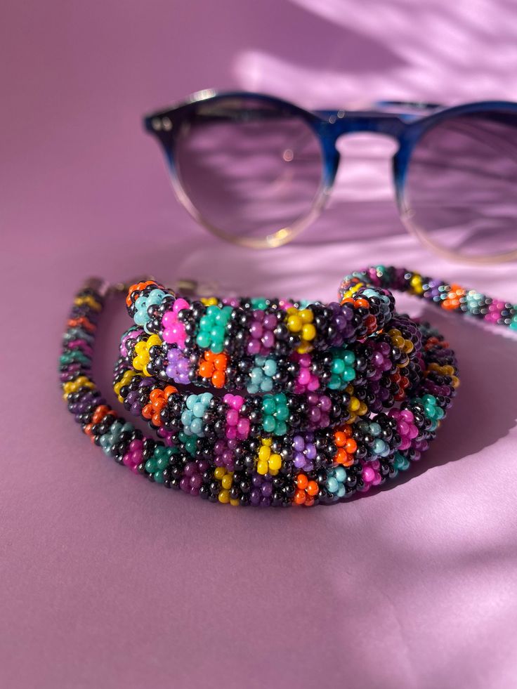 The perfect accessory for your wardrobe, adding a finishing touch to your outfit. Multi-functional glasses, sunglasses and mask chain holder with multi-colored beads. It can also be used as a necklace. Thank you in advance for choosing my designbycolla store. If you have a question, I can answer immediately. My three-functional product, which can be eyeglass chain, necklace, bracelet, is completely made with the help of handmade crochet. This eyeglass chain can be a very perfect choice for your Handmade Purple Beaded Necklace For Summer, Handmade Beaded Necklaces For Everyday Summer, Summer Handmade Purple Beaded Bracelets, Trendy Multicolor Glasses Chains, Handmade Adjustable Glasses Chains With Round Beads, Beaded Glasses Chains With Round Beads, Colorful Beads Glasses Chains As Summer Gift, Summer Glasses Chains With Colorful Beads As Gift, Multicolor Adjustable Chain Glasses Chains For Fashion