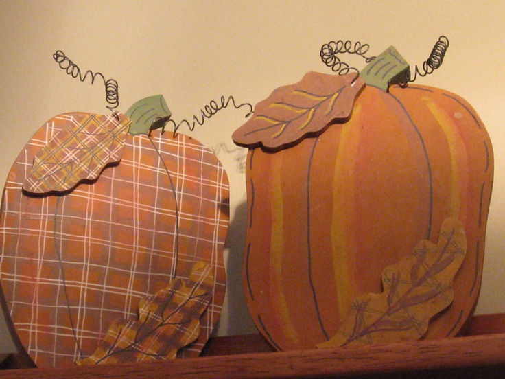 two decorative pumpkins sitting on top of a wooden shelf