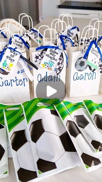 soccer themed bags with name tags on them sitting on a table in front of other items