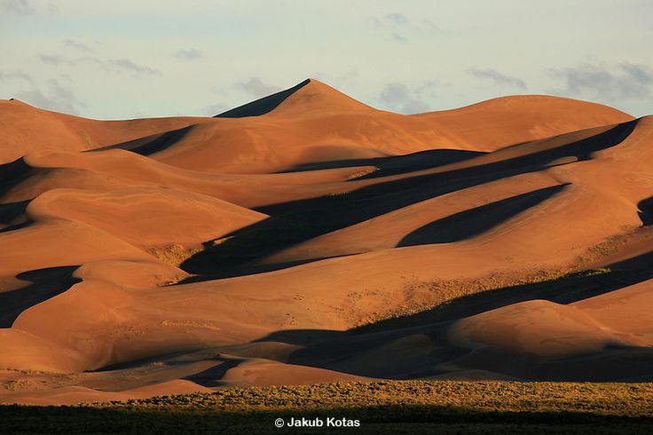 sand dunes in the desert under a cloudy sky