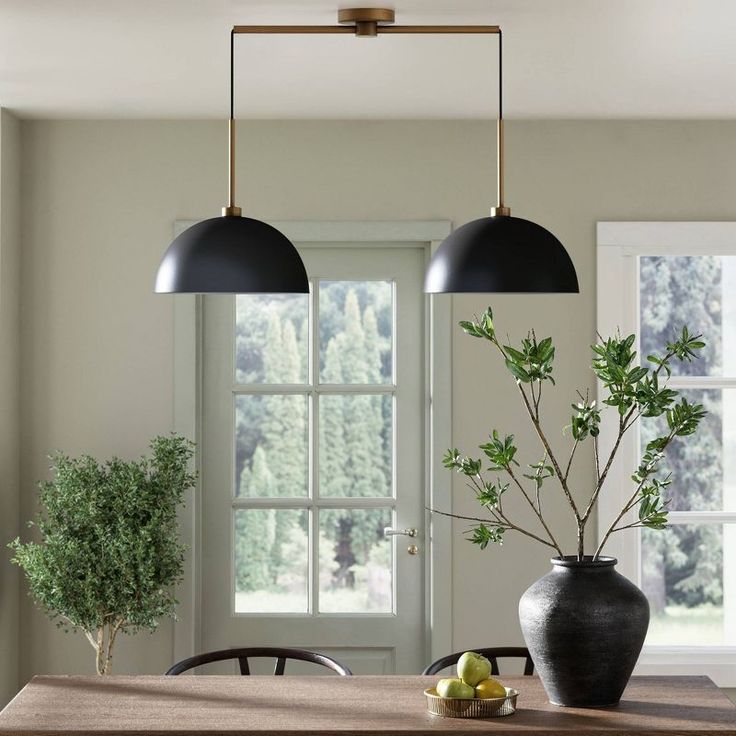 two black lamps hanging over a dining room table