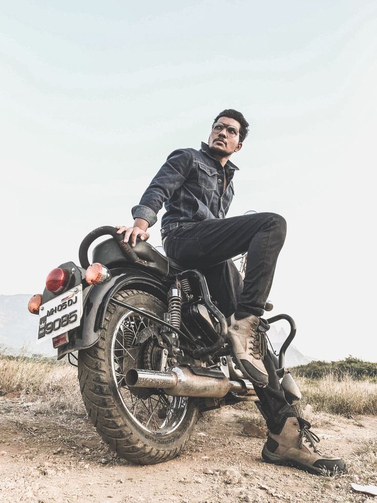 a man sitting on the back of a motorcycle