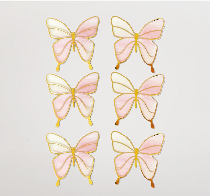 six pink and yellow butterflies with gold trimmings on them, all facing different directions