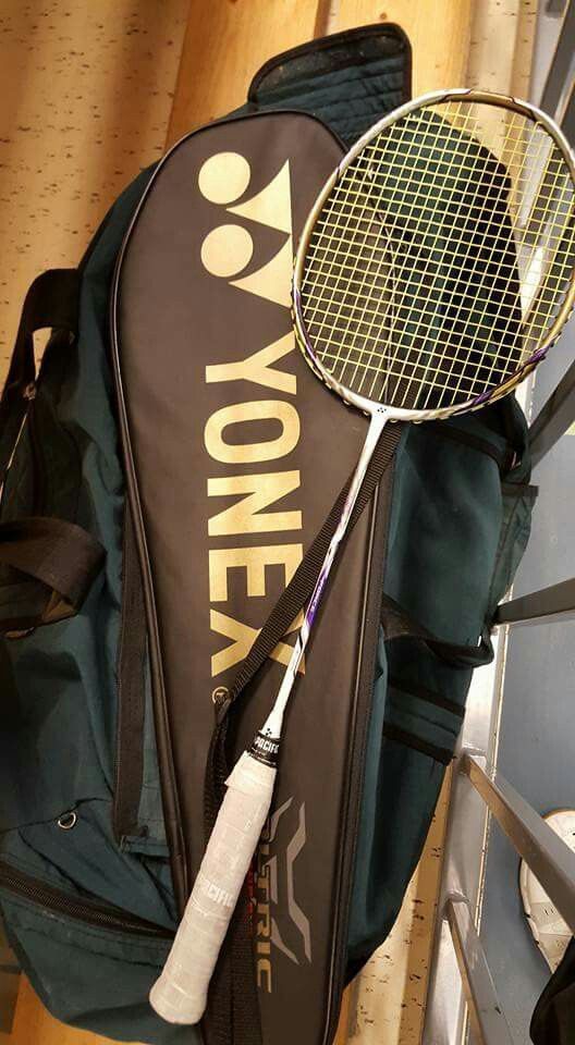 a tennis racket and bag sitting on the floor