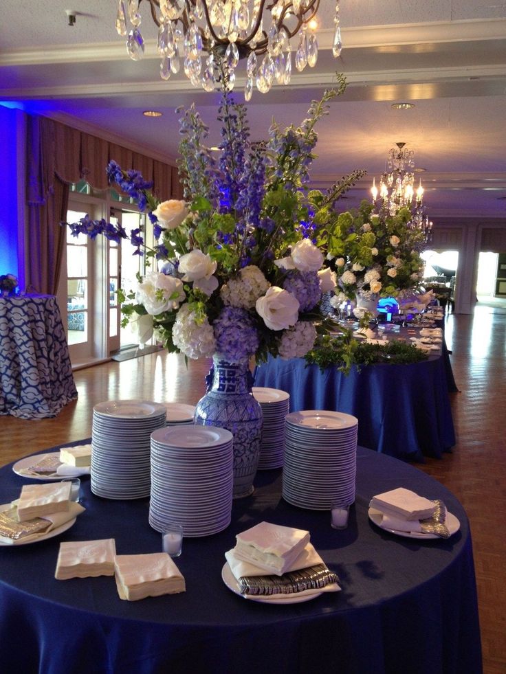 the table is set with plates, silverware and flowers in vases on it