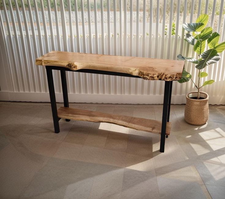 a wooden bench sitting next to a potted plant