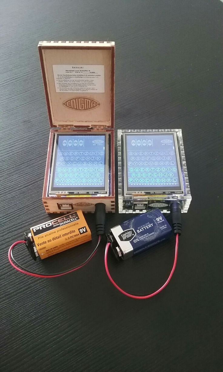 two electronic devices sitting on top of a table next to an empty box with wires