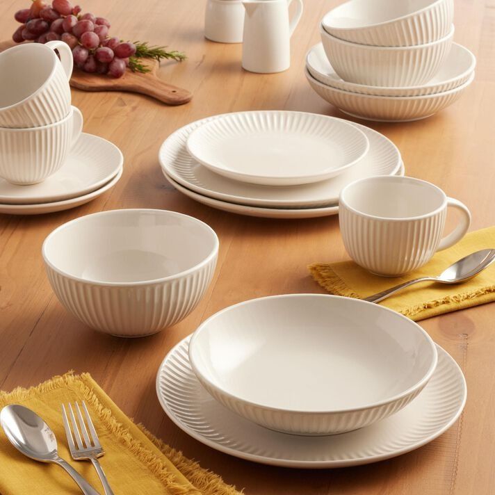 a table set with white dishes and silverware