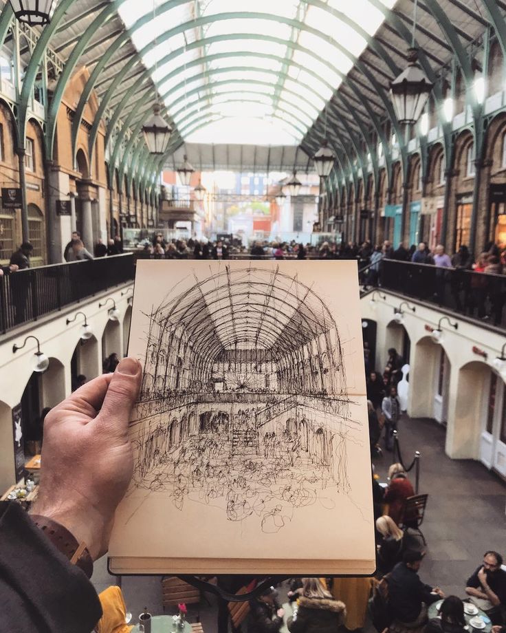 a person holding up a drawing in an indoor building