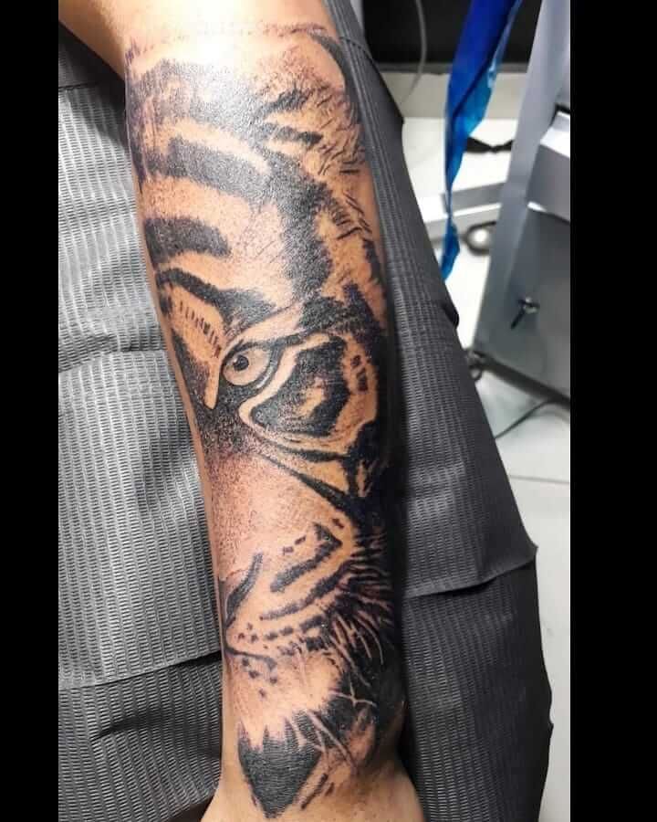 a man with a tiger tattoo on his arm