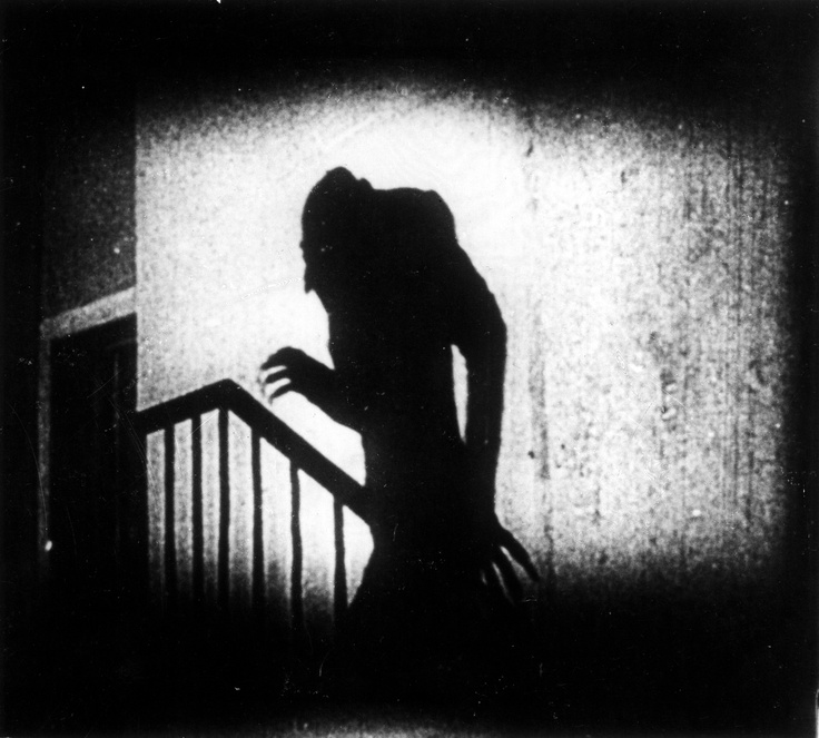 the silhouette of a woman standing on a stair case in an old black and white photo