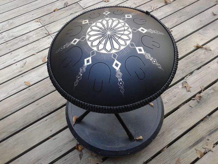 a black and white table sitting on top of a wooden floor next to a fence