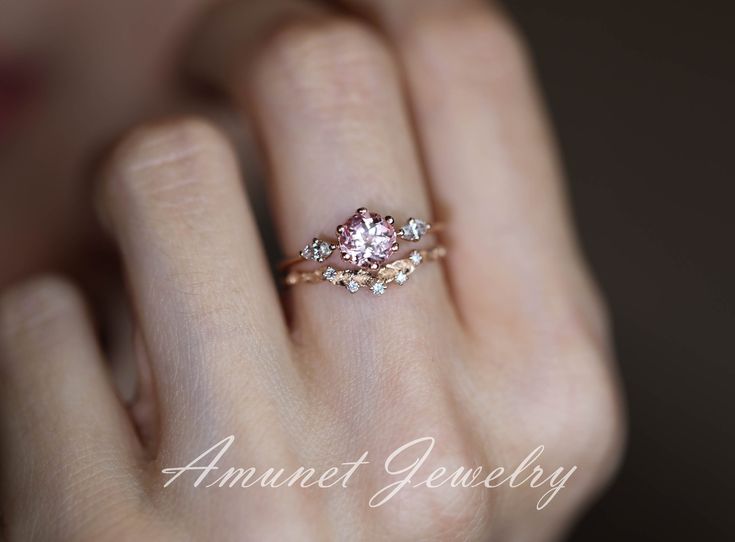 a woman's hand with a pink diamond ring on it