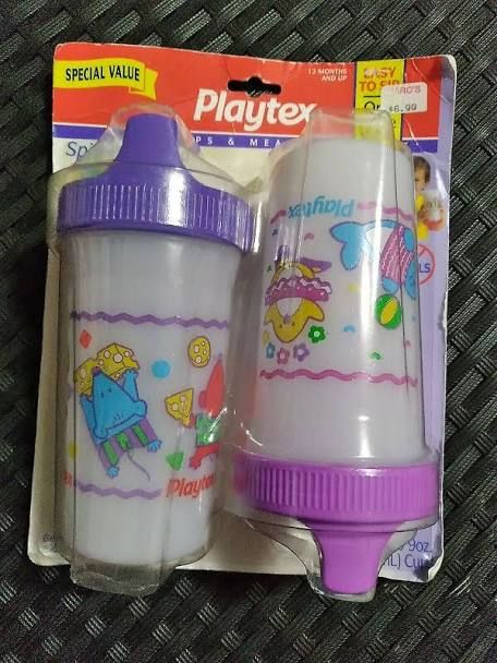 two plastic cups with cartoon characters on them sitting in front of a package for playtex