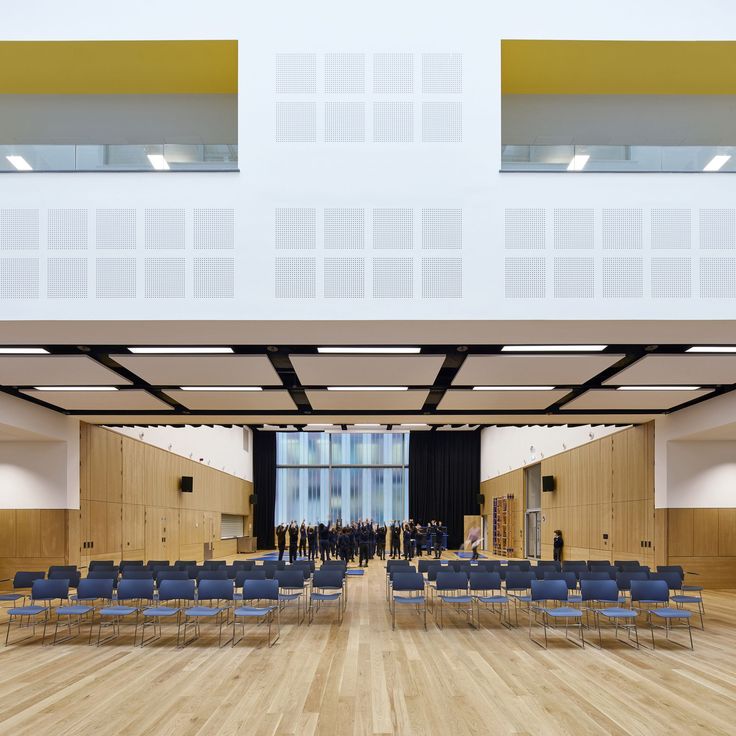 an empty room with blue chairs and wooden floors