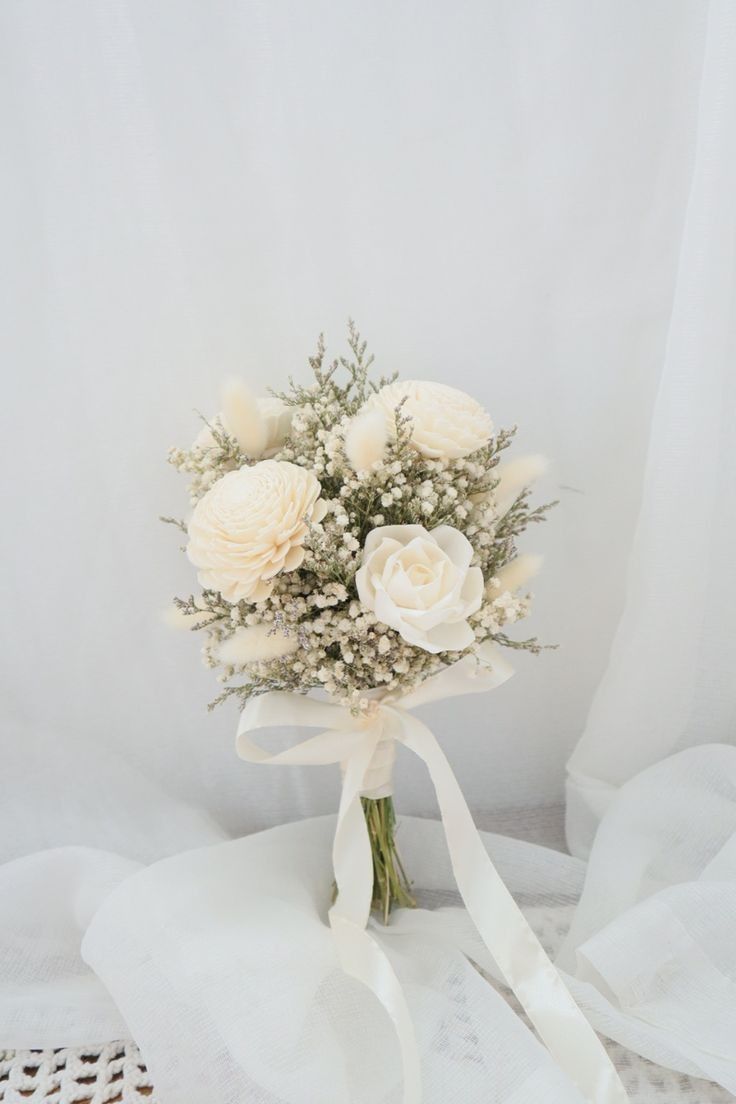 a bouquet of white flowers sitting on top of a table