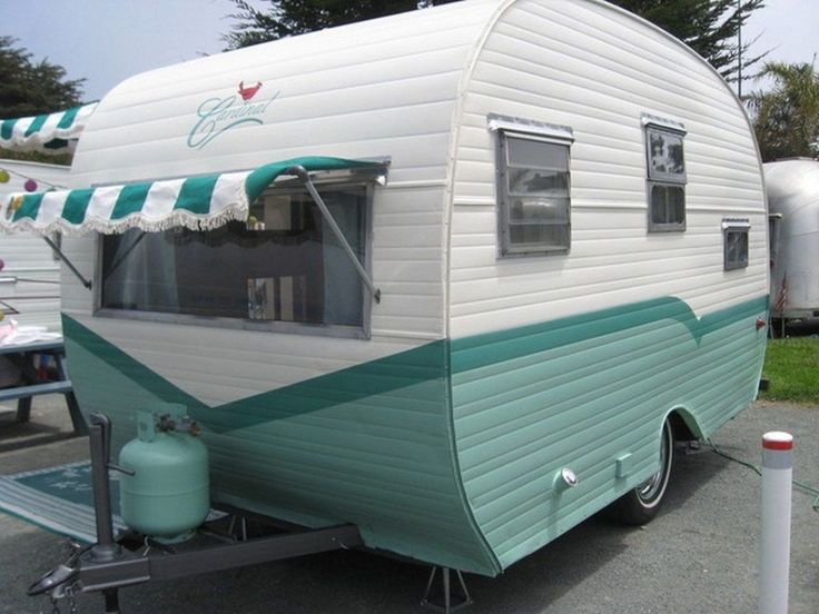 an old camper trailer parked in a parking lot