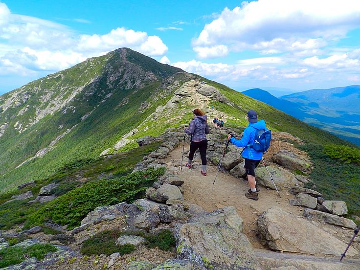 two people hiking up the side of a mountain