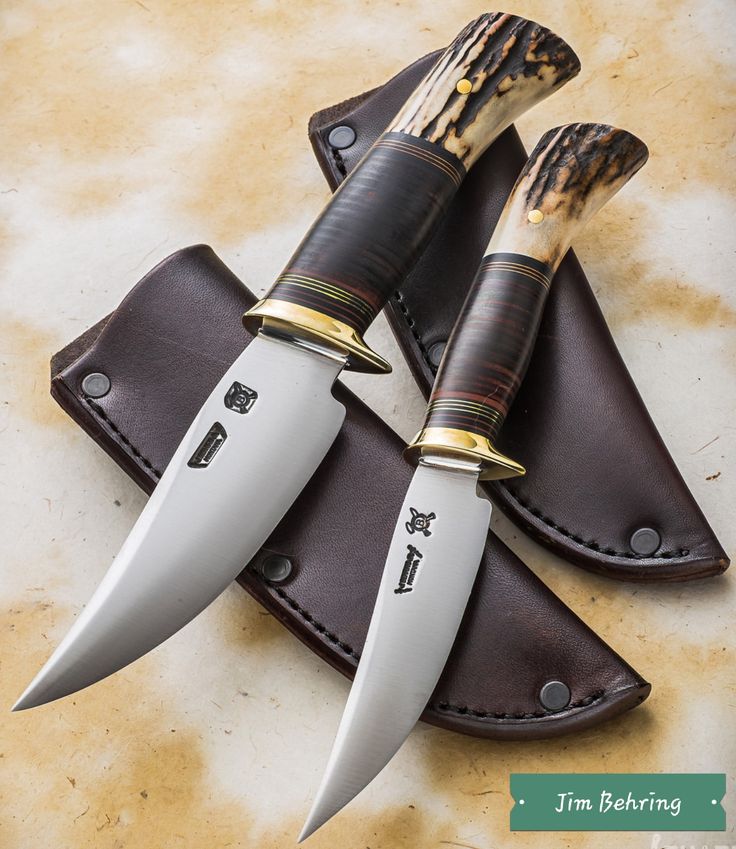 three knives sitting on top of leather sheaths