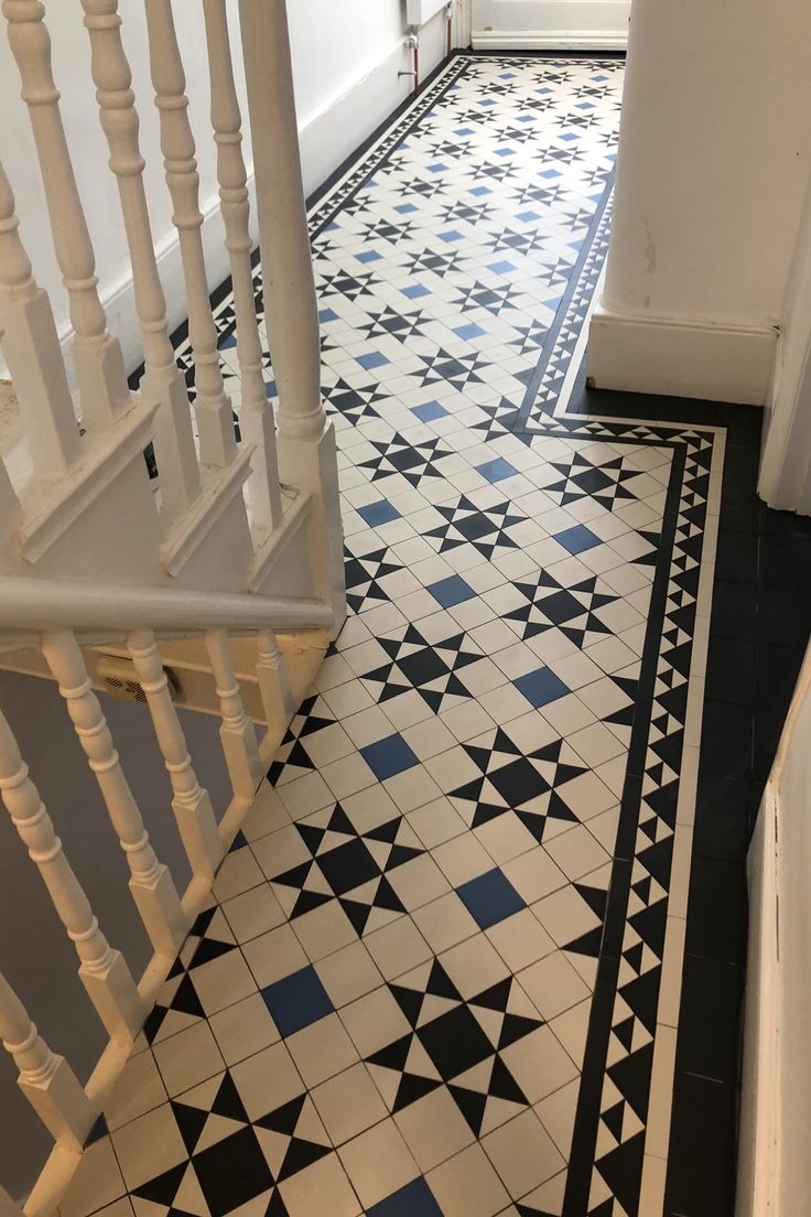 a black and white tiled floor next to a stair case