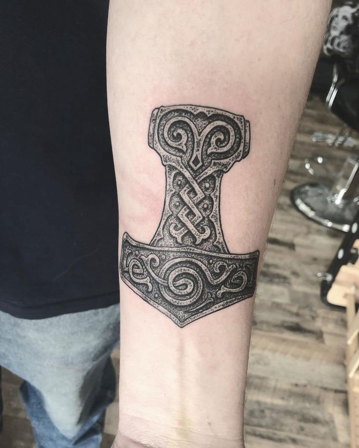 a tattoo on the arm of a man with an ax in it's center