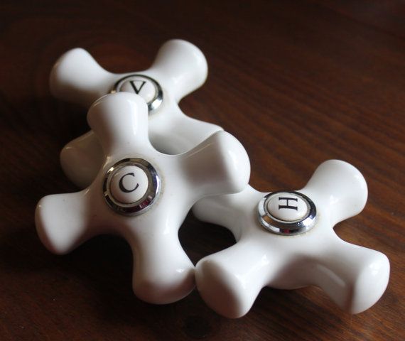 two white ceramic knobs sitting on top of a wooden table